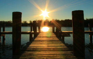 a fishing dock at sunset looking into the sun