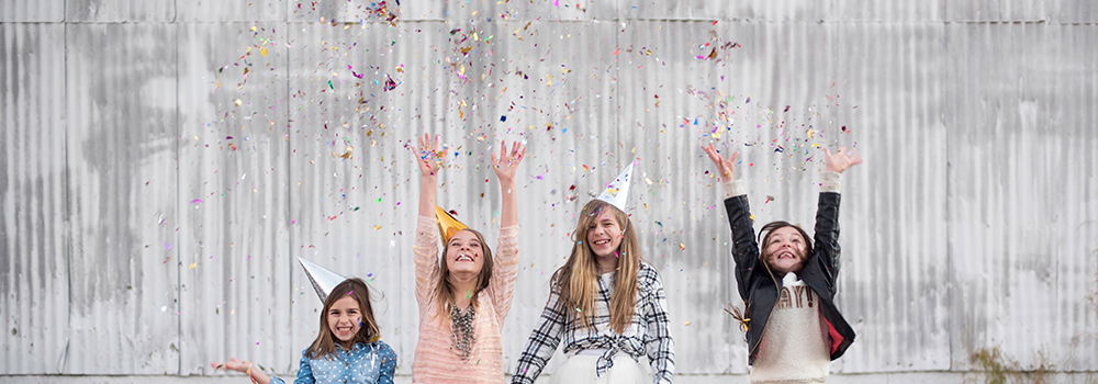 Youth girls celebrating with party hats and confetti
