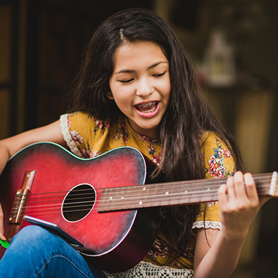 girl playing acoustic guitar